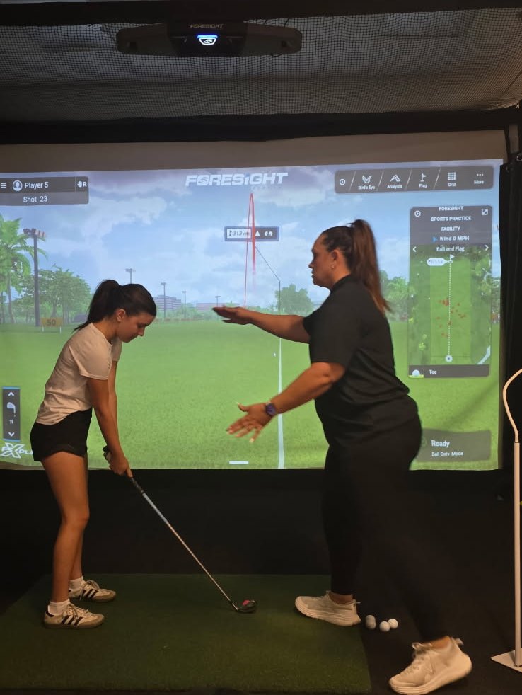 Jennifer Sweet-Lopez coaching a student in a simulator bay at No Bogeys Bakersfield